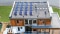 Imaginea prezintă o casă modernă cu module fotovoltaice Vitovolt pe acoperiș.